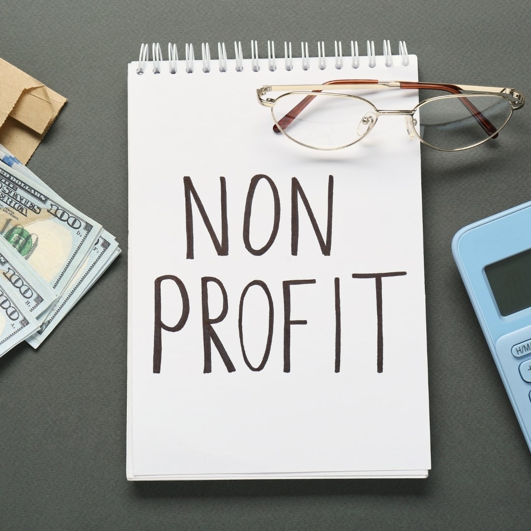 Notebook labeled non profit with cash and calculator representing SEO for nonprofit websites
